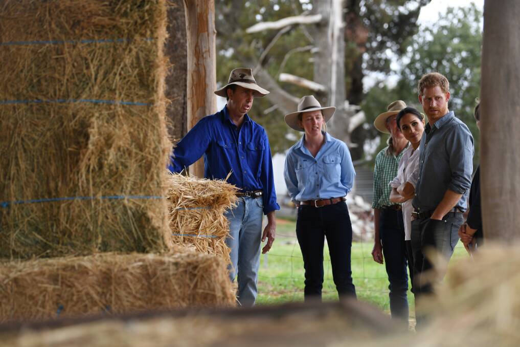 DROUGHT: Scott, Laura and Elaine Woodley show the Duke and Duchess of Sussex stockfeed and tell them about the impact of drought on Mountain View and other properties in the western region. Photo: DEAN LEWINS/ AAP