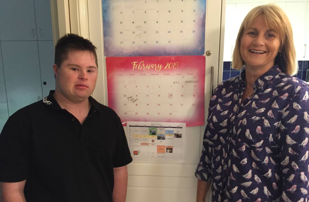 USER GROUP: Maree Barnes, founder of Orana People Using NDIS (OPUN), and son Joe check out his weekly timetable which includes NDIS-supported activities. Photo: KIM BARTLEY