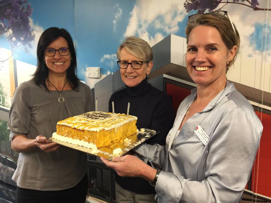 MARY'S FAREWELL: Bonita Jameson (left) and Kerrie O'Neill (right) encourage mentor and colleague Mary McCarthy to have another piece of her farewell cake on Thursday. Photo: KIM BARTLEY