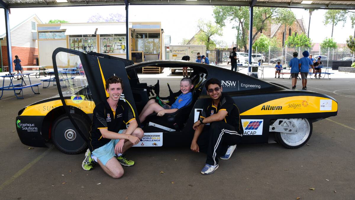 FULL OF ENERGY: Dubbo Public School student Izac Pearce takes a seat in eVe watched by Solar Racing Team Sunswift members Connor O'Shea (left) and Syed Ahmed. Photo: BELINDA SOOLE 