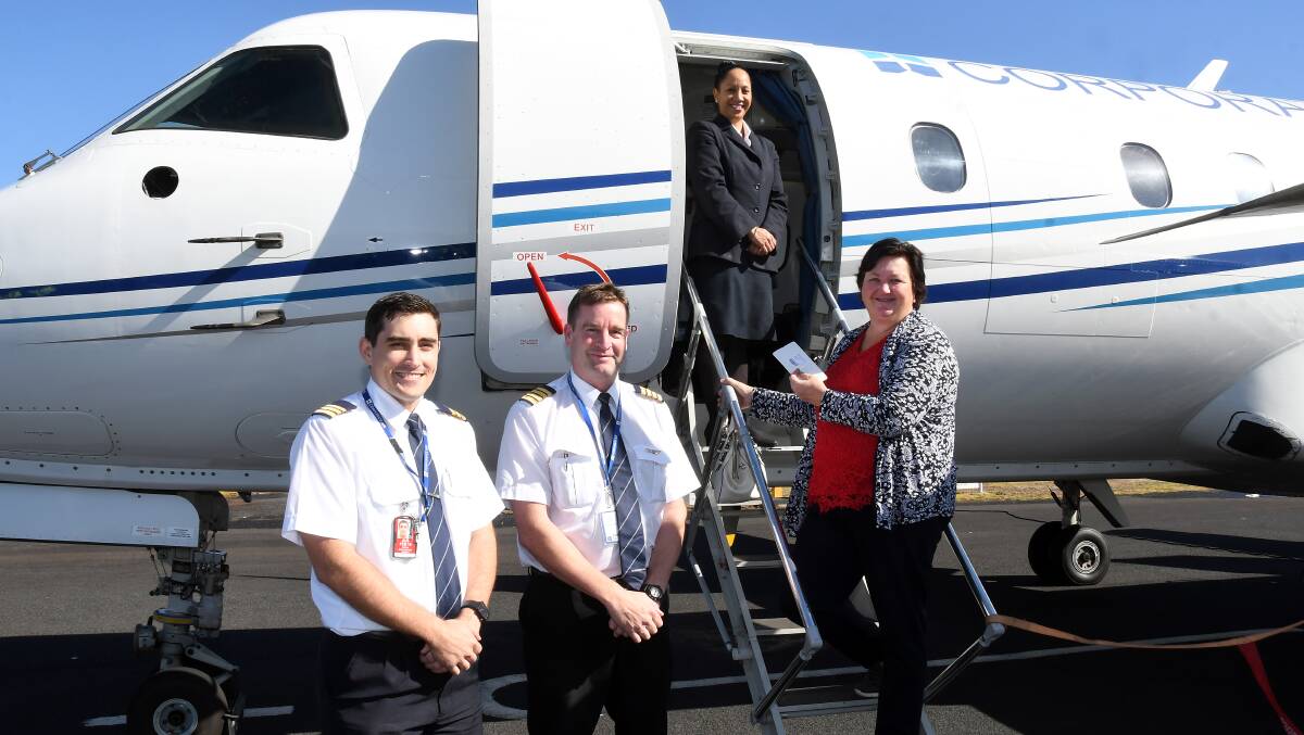 GOING HOME: Fly Corporate crew members Andrew Macpherson, Lachlan Burnett and Leighanne Gibbons welcome Janelle Hasler on board for Tuesday's return flight to Brisbane. Photo: BELINDA SOOLE