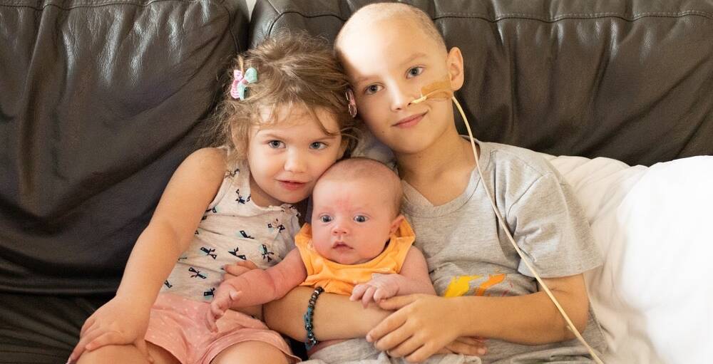 THREE OF A KIND: Dubbo's Hannah, Connor and Mitchell Ray cuddle. Six-year-old Mitchell is currently being treated for stage four cancer at a Sydney hospital. Photo: Contributed.