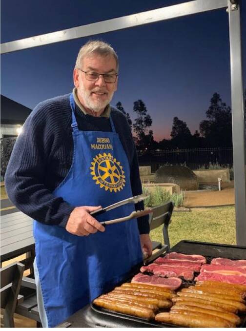 Rotary Club of Dubbo Macquarie's John Stonestreet cooks meat on the barbecue for a dinner at Macquarie Home Stay. Photo: Contributed