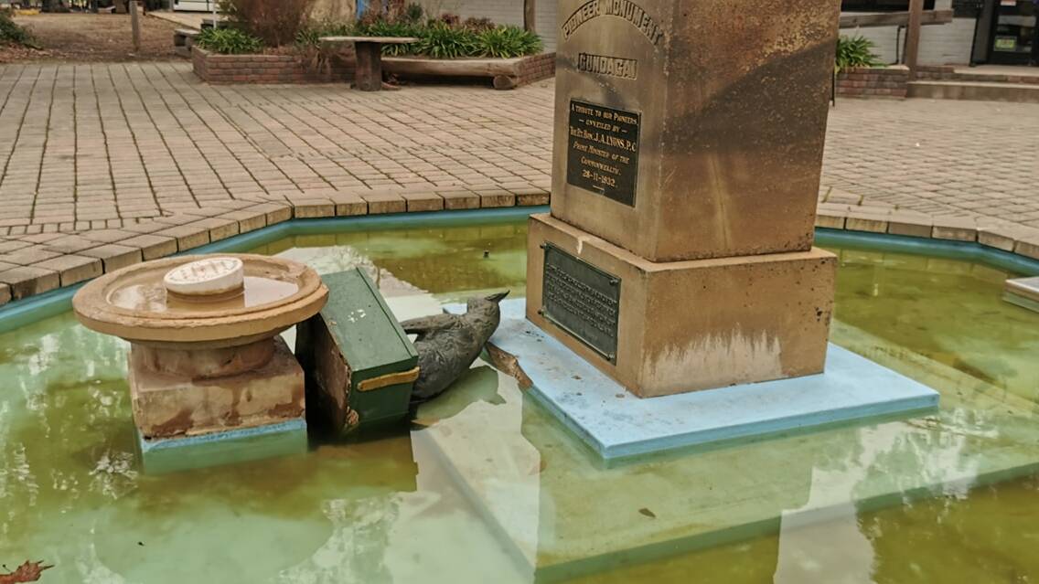 Sad sight: Troublemakers left Gundagai's famous dog and its tuckerbox in the wishing well below its plinth after toppling it on Saturday afternoon. Picture: LOST GUNDAGAI FACEBOOK