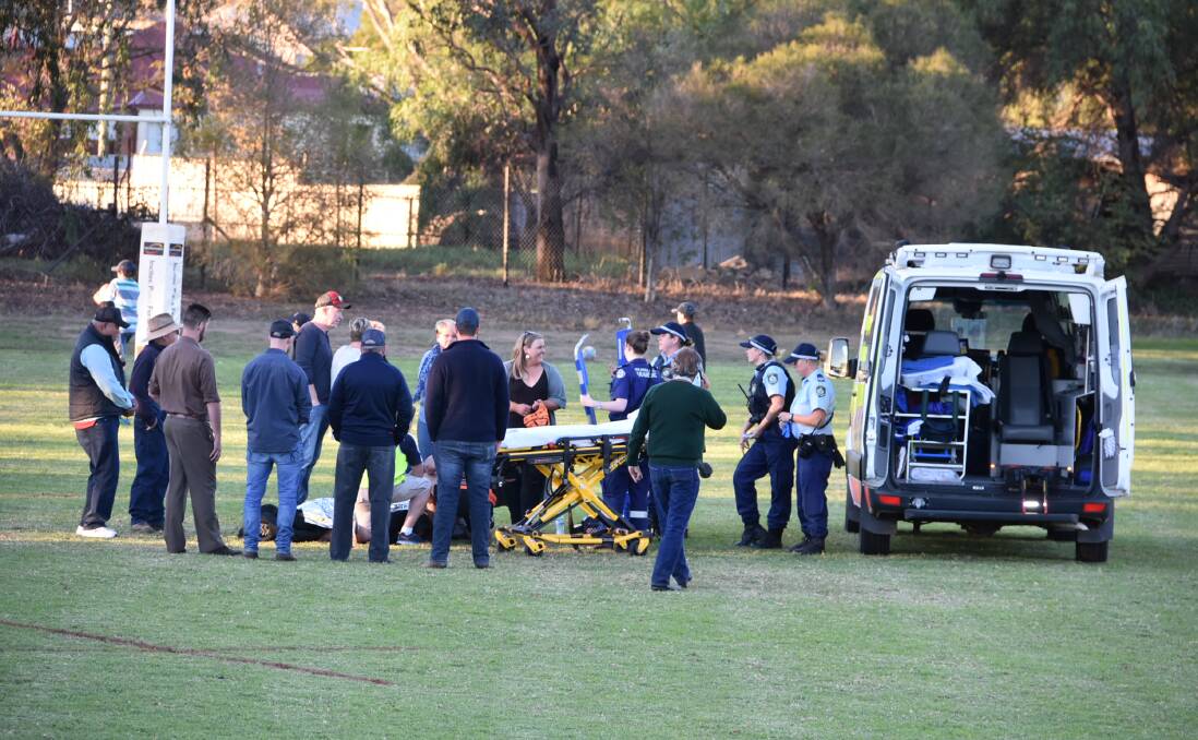 SAD SCENE: Players, coaches, officials and emergency personnel attending to Orange City Lions captain Josh Tremain on Saturday.
