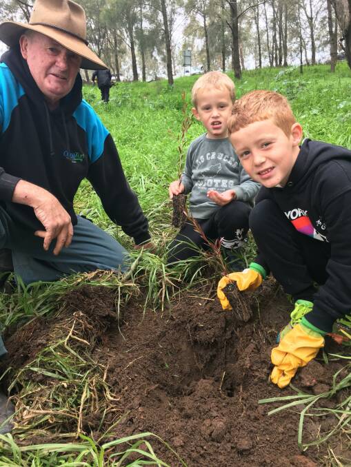 WORTHY HONOUR: Mick ONeill, pictured here planting trees with his grandkids, has received and Order of Australia Medal. Photo: CONTRIBUTED