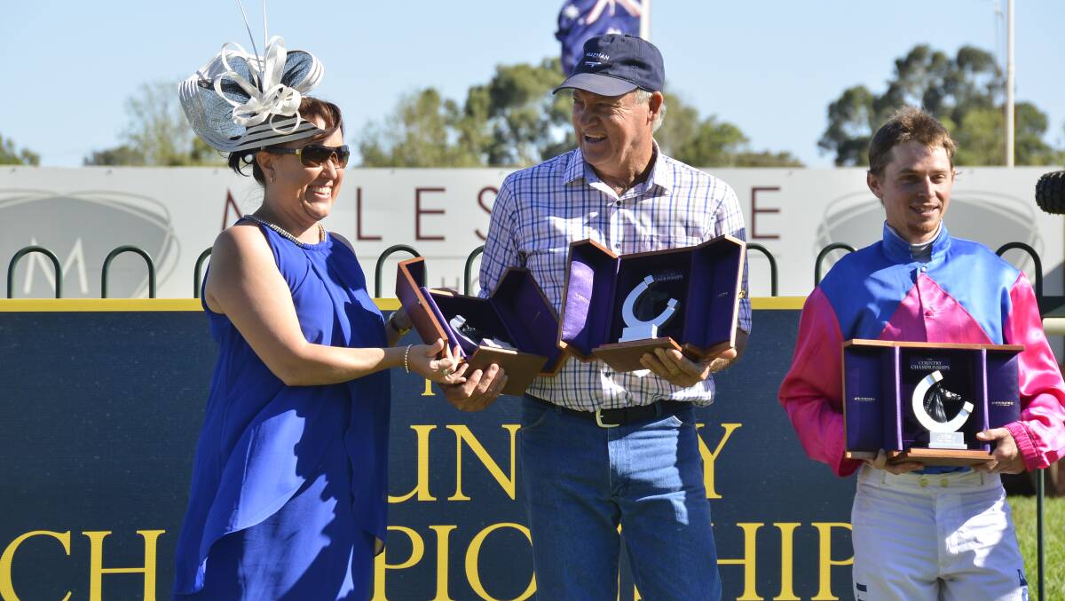 WINNING FEELING: James Hatch (centre) celebrates with the silverware after Stoneyrise's win at Dubbo. Photo: BELINDA SOOLE