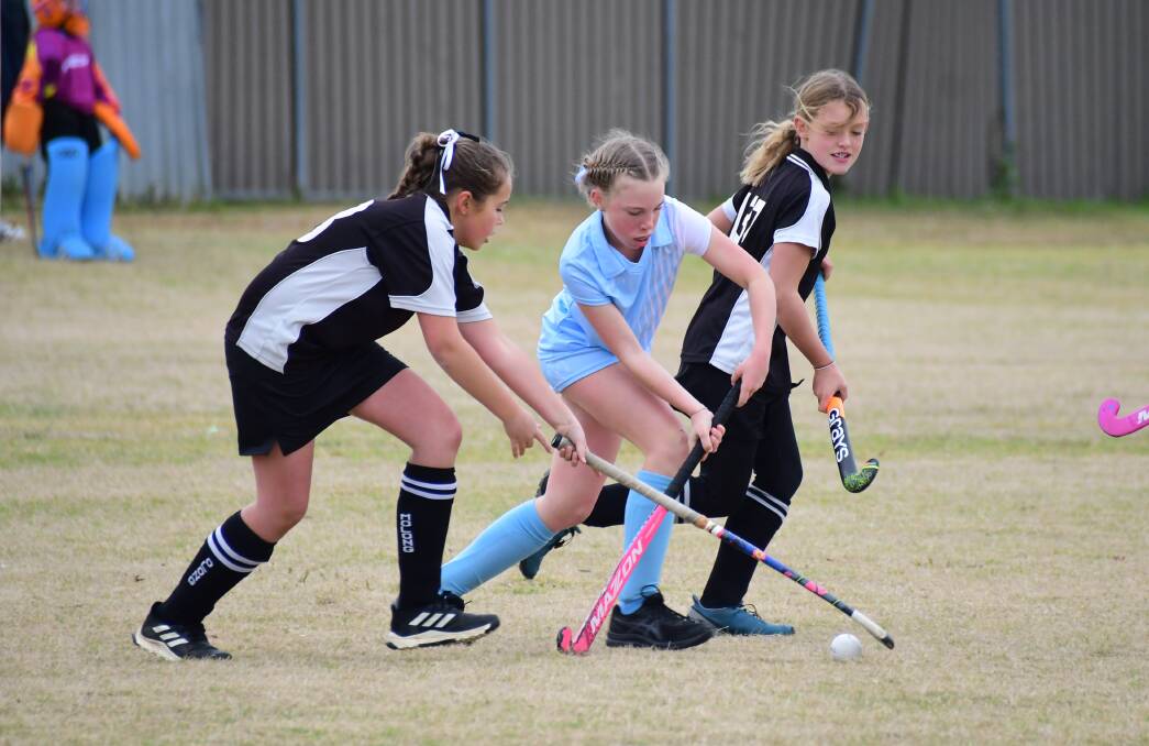 CONTACT: Players and families from the Molong Hockey Club (black and white) were among those in Dubbo on the weekend. Photo: AMY McINTYRE
