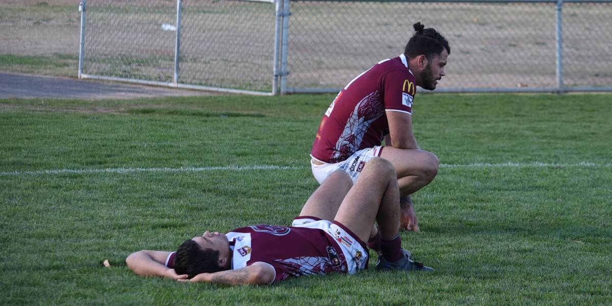 SHATTERED: CJ Ralph (front) and Justin Toomey-White slump to the turf late on in Sunday's preliminary final loss. Photo: NICK GUTHRIE