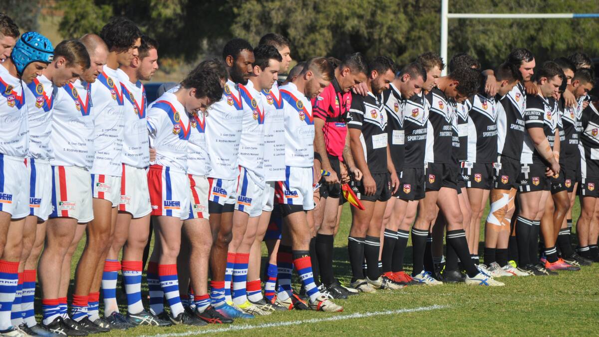 TOGETHER: Parkes and Forbes player observe a minute's silence before the derby clash. Photo: NICK McGRATH