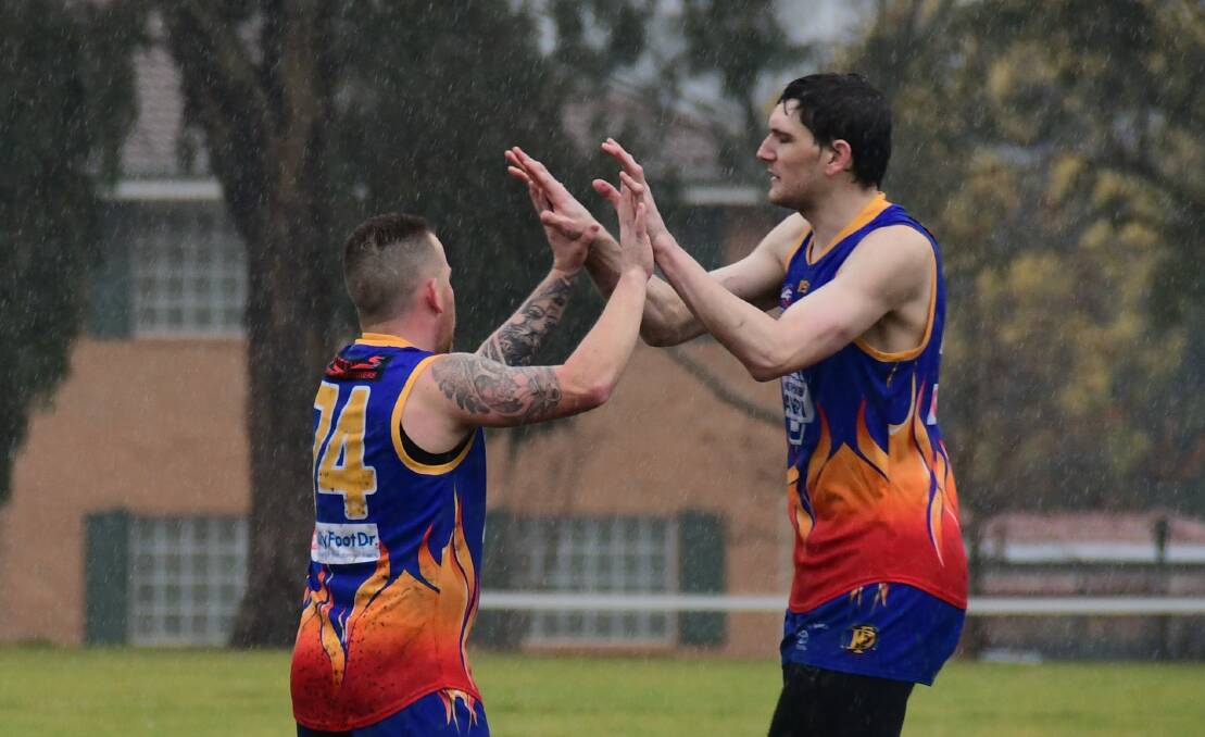 ON A ROLL: Joey Hedger (left) and Josh Anasis celebrate a goal during the Demons' win at a sodden South Dubbo Oval last weekend. Photo: AMY McINTYRE