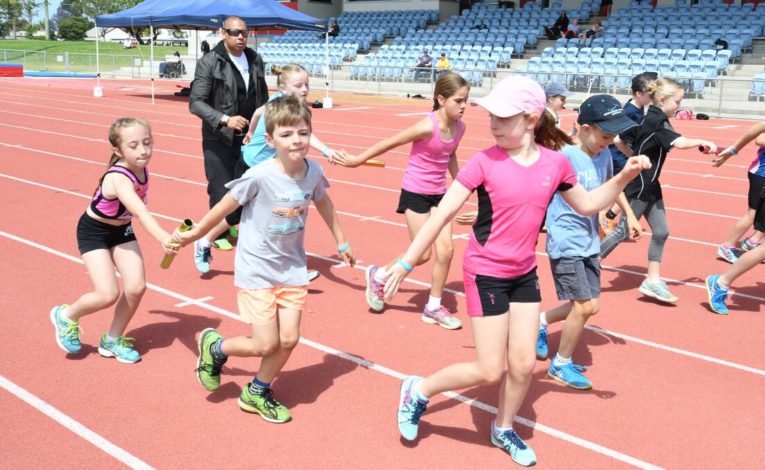 HELPING HAND: Patrick Johnson watches on and passes on tips during a relay and baton passing lesson at Barden Park on Sunday morning. Photos: BELINDA SOOLE