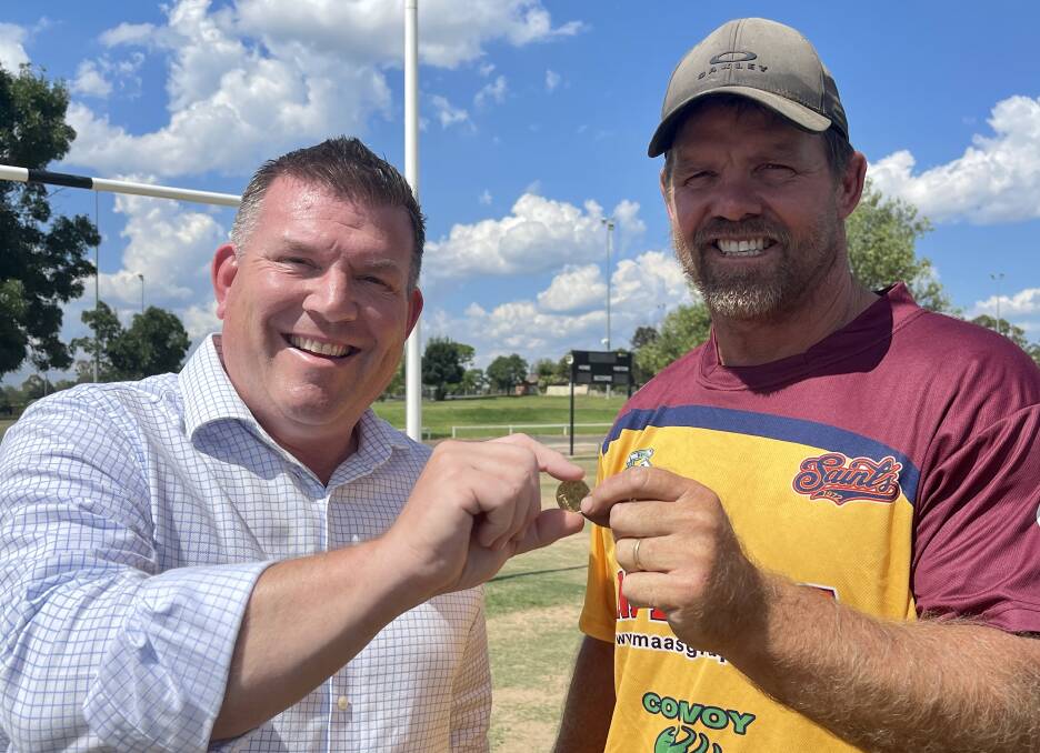 HELPING HAND: Dubbo MP Dugald Saunders and Bernard Wilson with the $1 coin that takes a grant for the club up to $1 million. Picture: Supplied