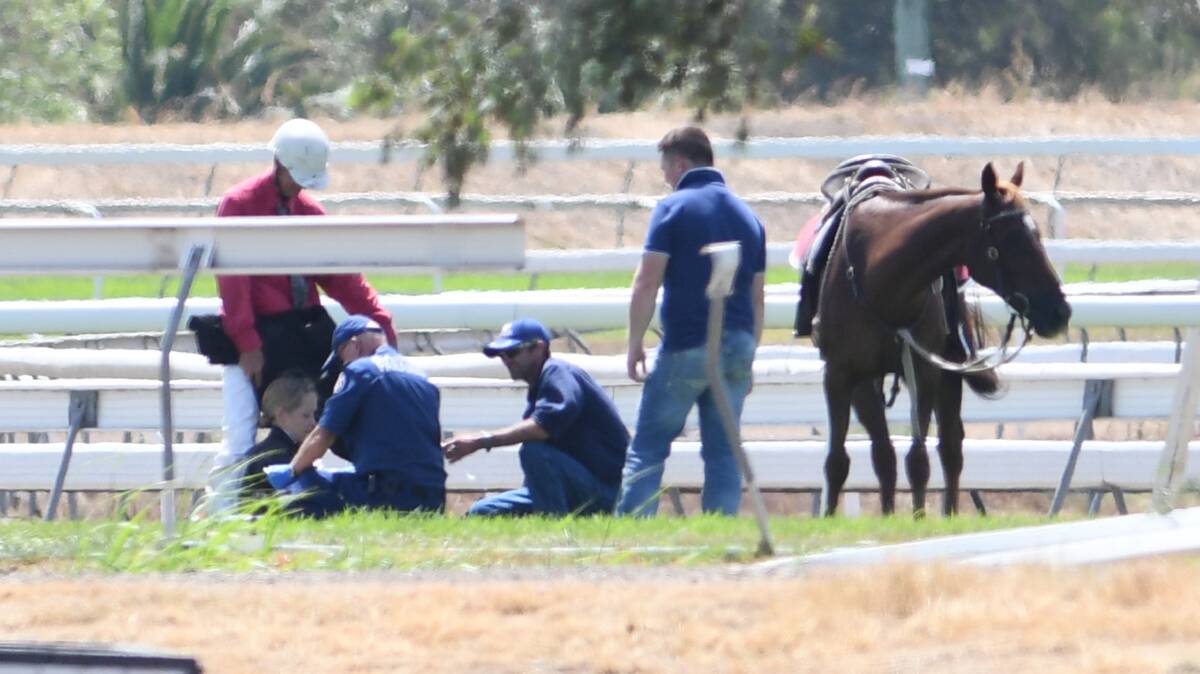 HORSE FALL: Paramedics were on scene to tend to the fallen jockeys after the domino-effect incident on Sunday. Photo: GARETH GARDNER