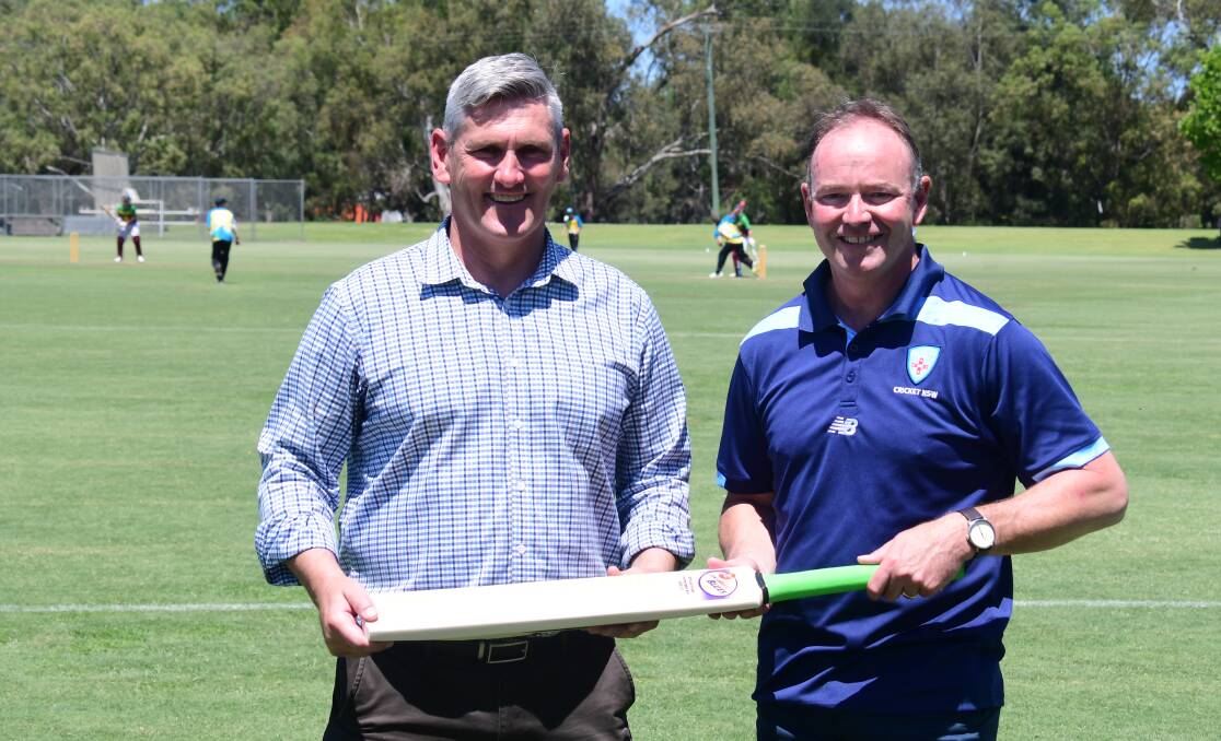 REWARD: Cricket NSW CEO Lee Germon (right) presented his Dubbo Regional Council counterpart Murray Wood with a signed bat as a gesture of thanks on Tuesday. Picture: Nick Guthrie