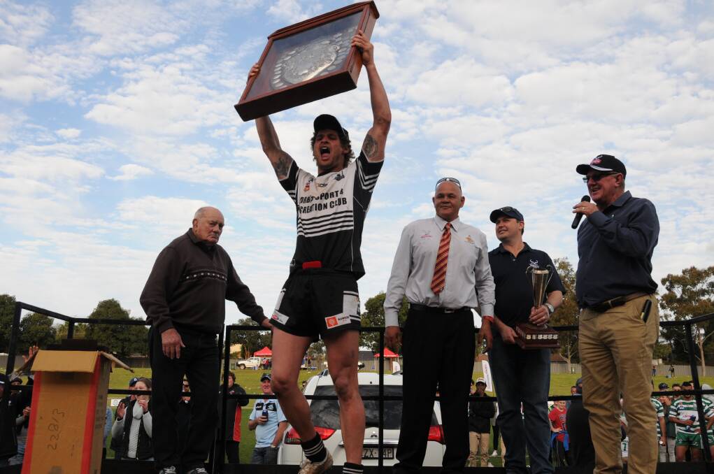 SPECIAL MOMENT: Jake Grace celebrates with the silverware after the Magpies won the grand final. Photo: BELINDA SOOLE