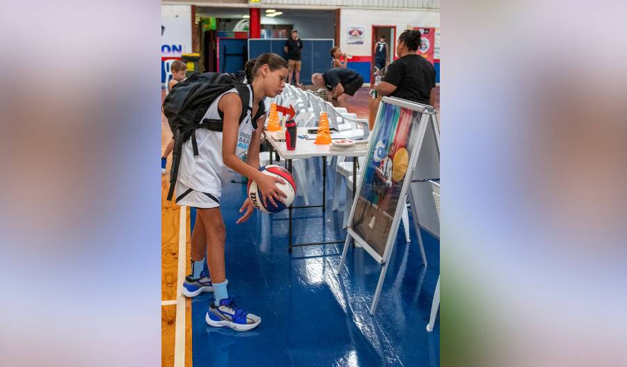 A junior player spends a moment with the photo of Australian great Patty Mills prior to the opening round of play at Dubbo on Sunday. Picture by Belinda Soole