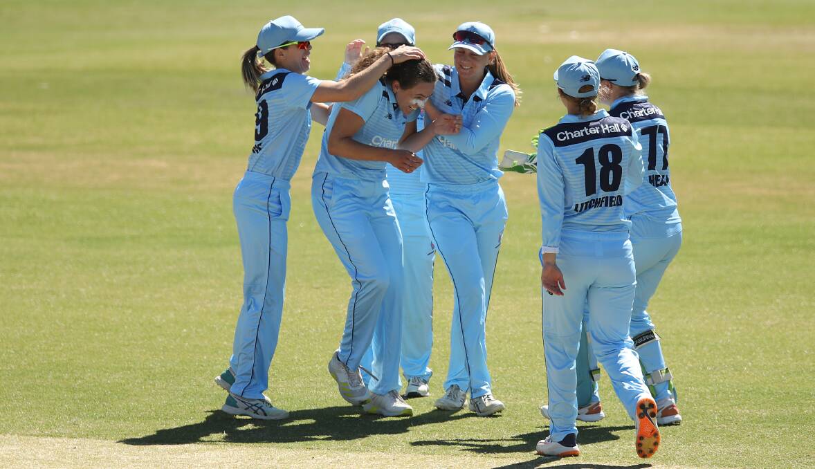 GET AROUND ME: Emma Hughes was mobbed by teammates and copped some treatment after taking her first wicket for the Breakers. Picture: Getty Images via Cricket NSW