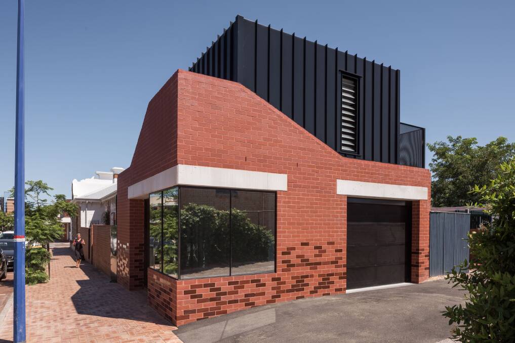 The charcoal aluminium cladding above was intended to recess into the background, allowing the street level scale to dominate.
