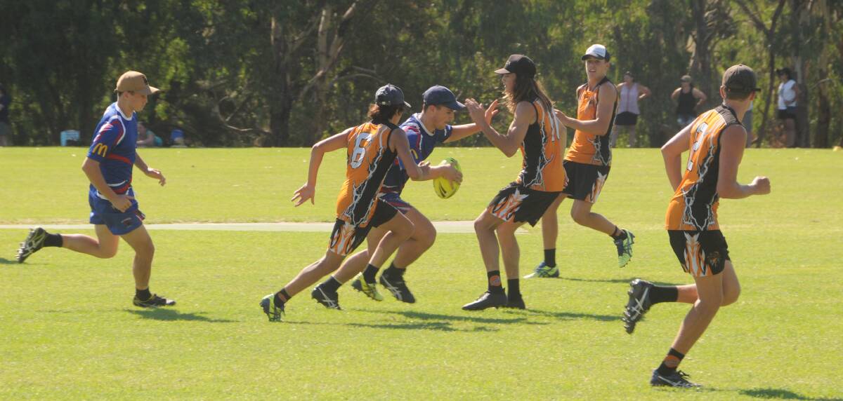 Nowhere to go: A Parkes player is wrapped up by the tight Orange defence in the under 18s grand final on Sunday. Photo: MARK RAYNER