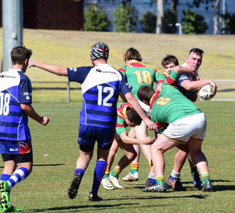 Options: Figtree's Matthew Nicholson looks to pass despite the attention of St John's Lismore in the Open Country Cup final. Photo: BELINDA SOOLE