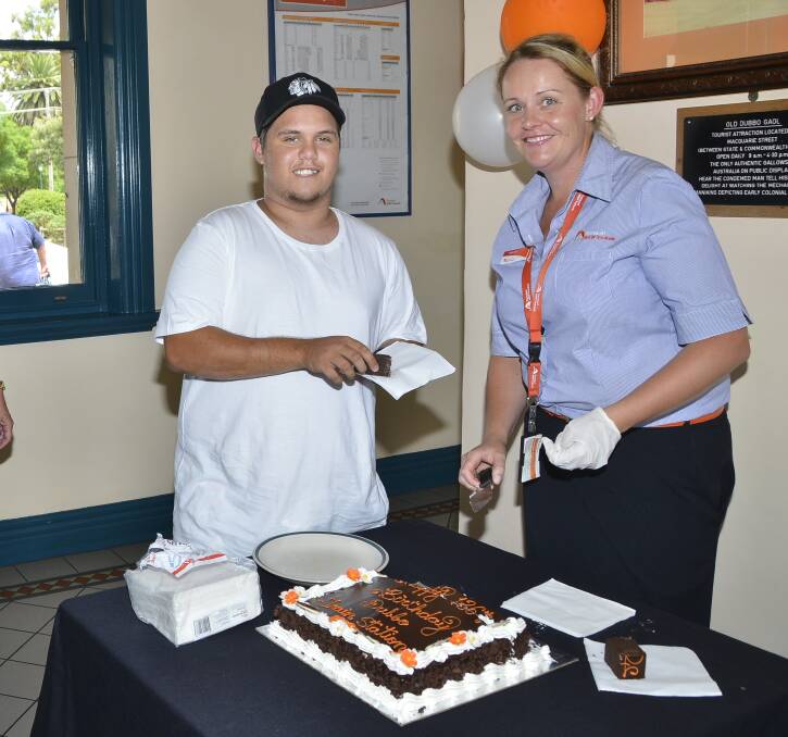 Passenger Joseph Gordon gets a piece of cake from NSW Trainlink area customer service manager Belinda Roberts. Photo: BELINDA SOOLE