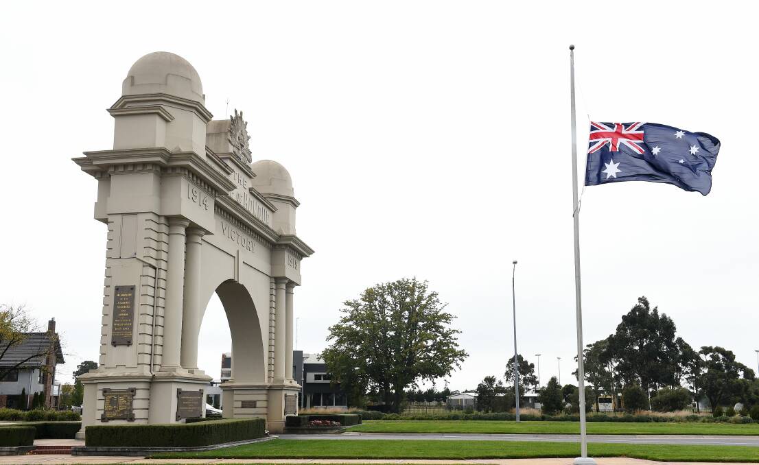 Honour: An Australian flag at half-mast at the Arch of Victory on Remembrance Drive at Ballarat in memory of the police officers who died in a car crash in Melbourne on Wednesday. Photo: Adam Trafford.