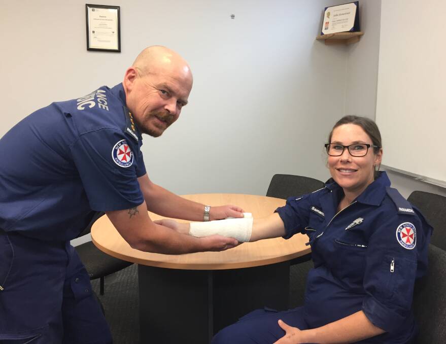Correct approach: Inspector Chris Wilson from NSW Ambulance and paramedic Sam Baker demonstrate applying a bandage. Photo: FAYE WHEELER