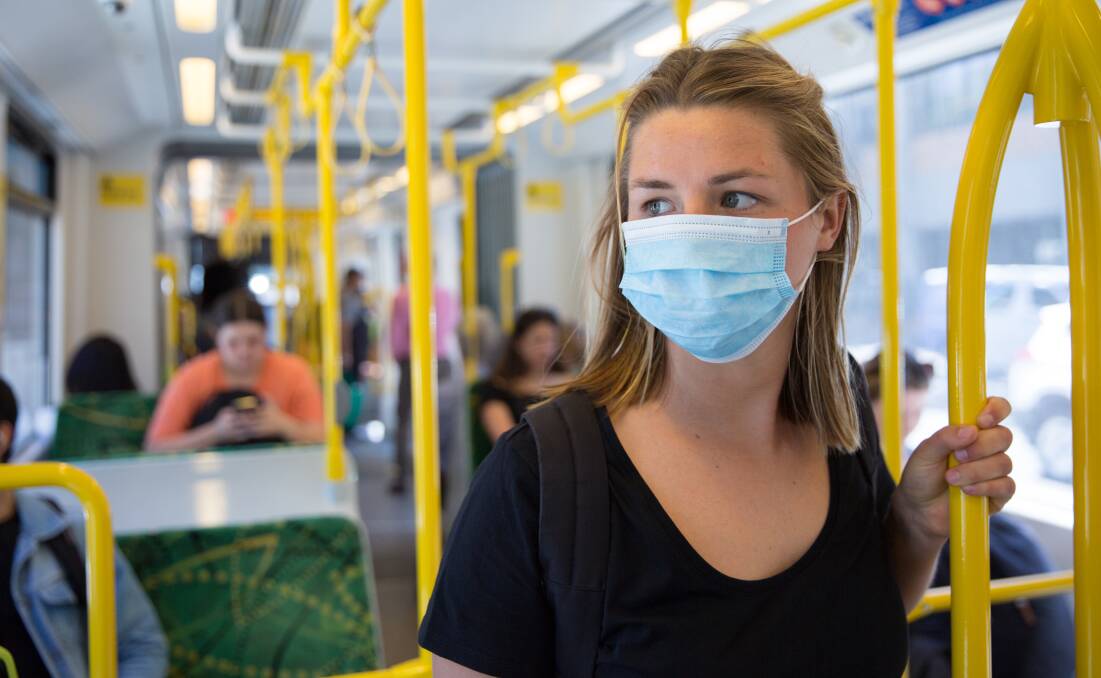 Woman wearing a mask on public transport. The Rural Doctors Association of Australia advises masks should be used in any place where physical distancing is not possible. Photo: Shutterstock.