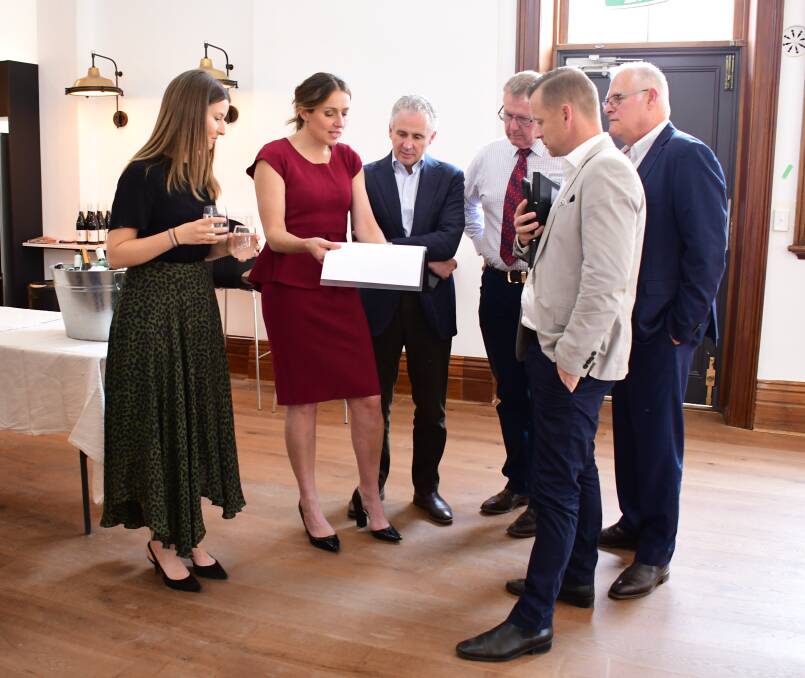 Fruition: The Exchange - Clock Tower owner Jillian Kilby (second left) shows Telstra CEO Andy Penn (third left) how the restoration project progressed. Photo: BELINDA SOOLE