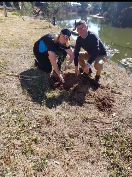 Working Together: Cassie Price from OzFish plants a tree with Landcare NSW CEO Dr Adrian Zammit in Dubbo's Wiradjuri Park. Photo: Provided.