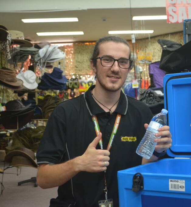 COOL: Staff member Justen Beehag with one of the 72 bottles of water being given out for free. Photo: Daniel Shirkie.