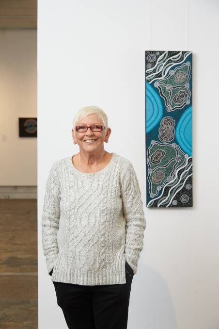 History: Wiradjuri artist Sharon Smith beside her artwork that was chosen to be displayed by the Newell highway. Photo: Supplied.