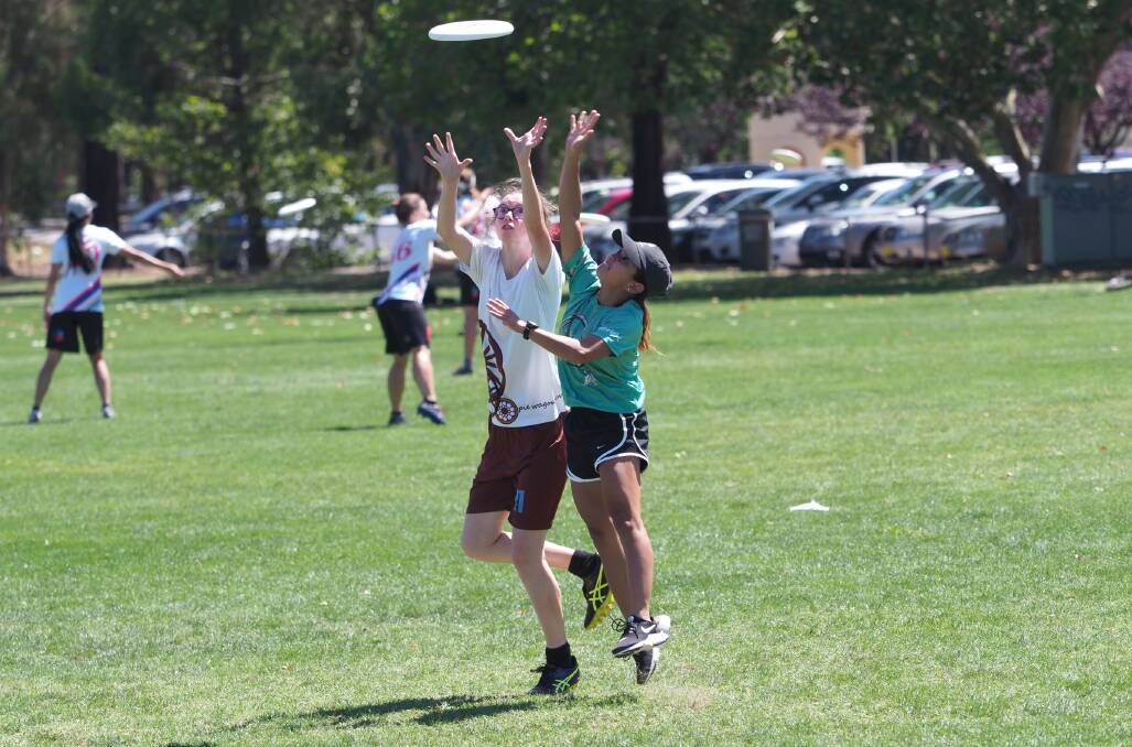 BID: Danielle Adams (Newcastle) and Jay Yambao (Dubbo) compete for the disc at last year's NSW Championships. Photo: SCOTT GEORGE