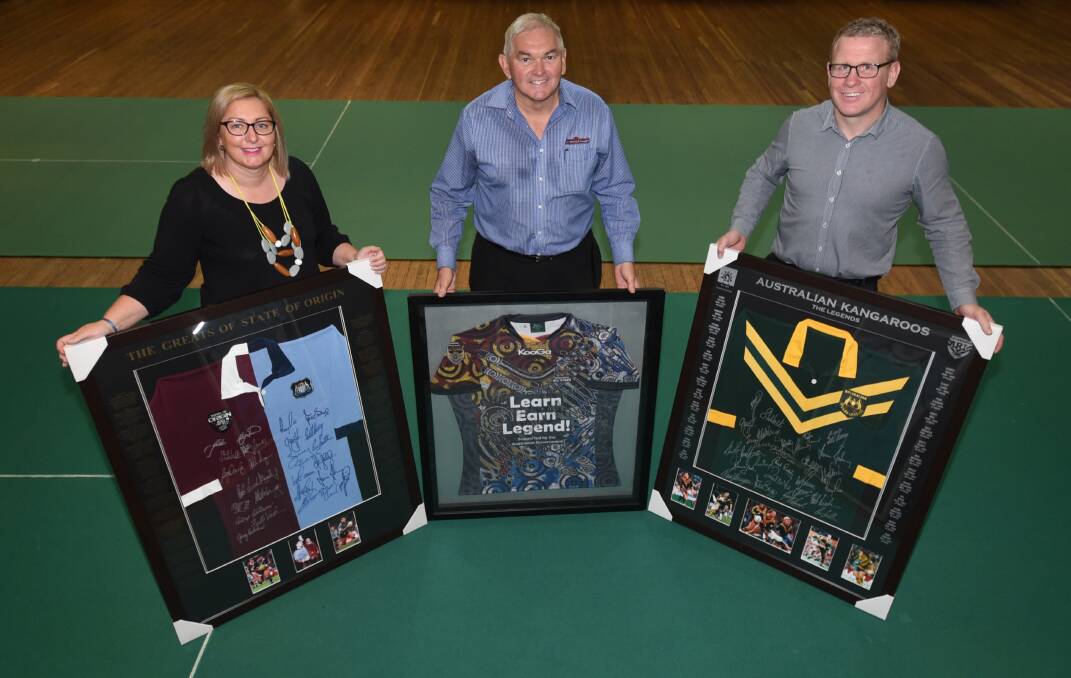 DOIN' IT FOR MOLLY: Kylie McKeown, Jim Kelly and Martin Cook with just some of the items to be auctioned on Saturday. Photo: BELINDA SOOLE