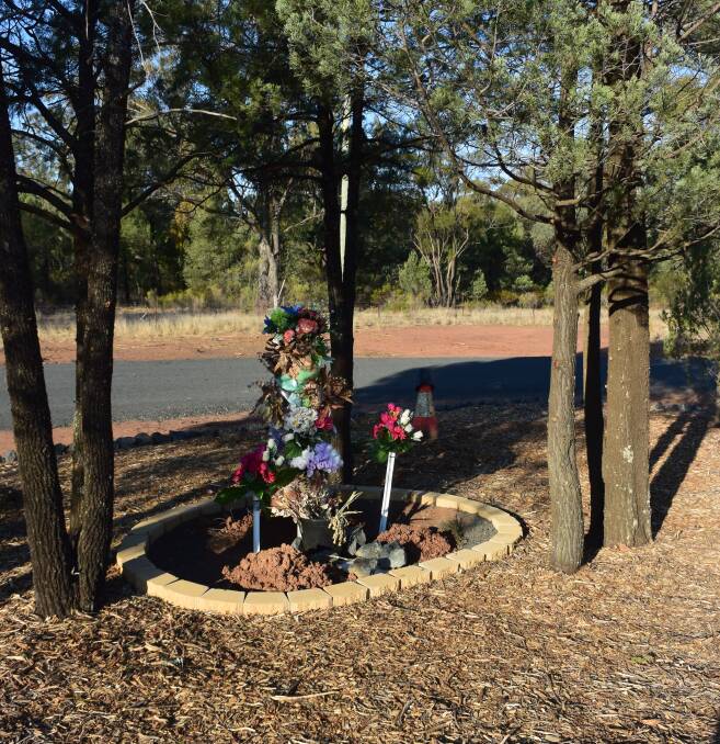 CONDOLENCES: The memorial on the Newell Highway. A makeshift sign reads 'Dear family & friends, just letting you know that the memorial is in progress and will be completed after Easter. Regards, RMS boys". Photo: JENNIFER HOAR