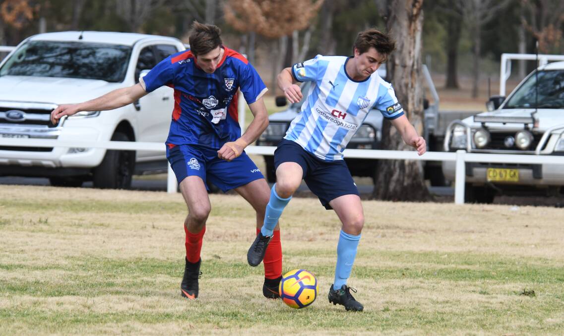 CHALLENGE: Jake Grady makes a tackle on Macquarie United's Glen Shein in Orana Spurs' upset win on Sunday. Photo: AMY MCINTYRE