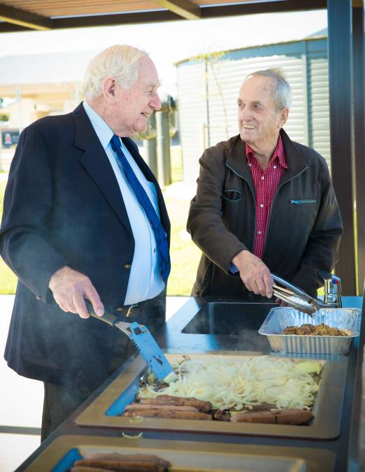 Helping Hands: Whether it's cooking up sausages or helping with activities, resident Derek Whitten and volunteer Noel Conroy are always keen to be involved. Photos: Supplied.