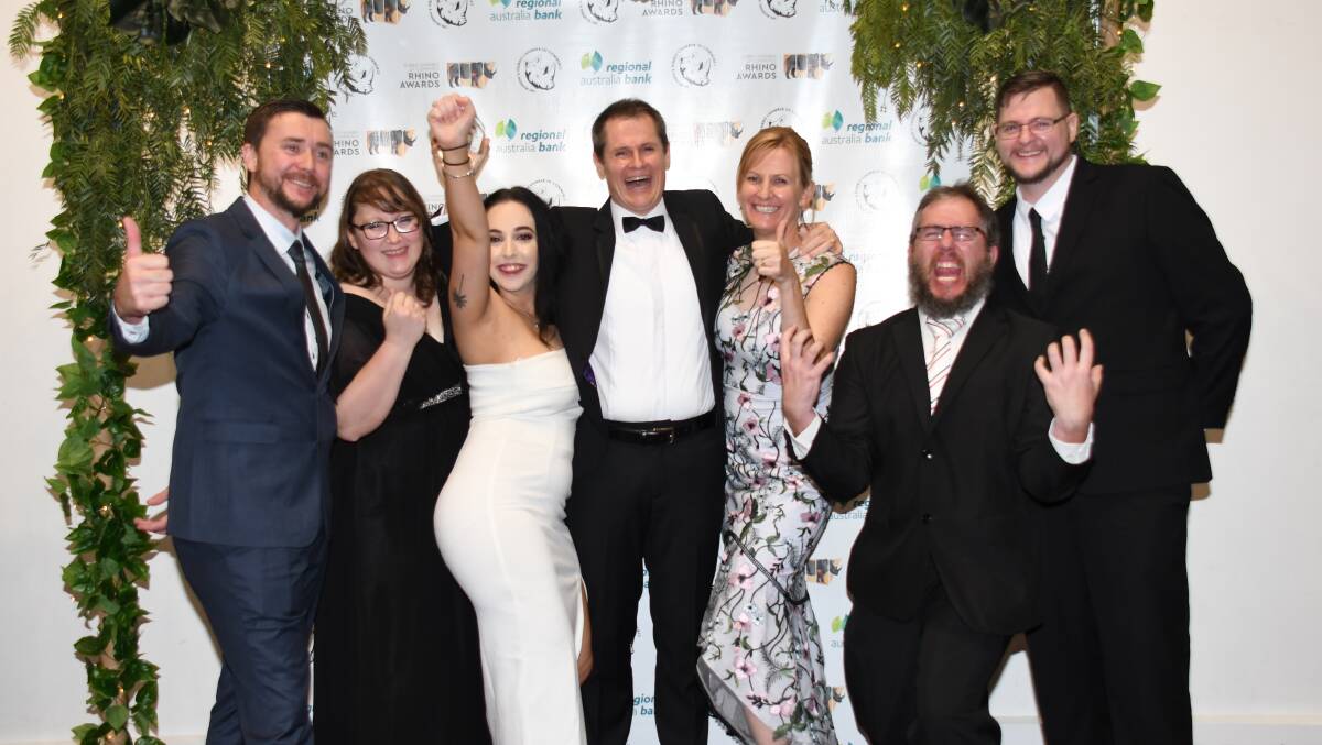 Winners are grinners: Mathew and Katrina Dickerson (centre), surrounded by some of the very successful team from Axxis, who took out this years Outstanding Employer of Choice at the Rhino Awards. Photo: File.