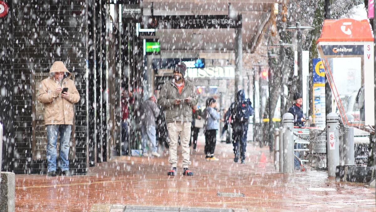 SNOW TIME: Summer Street pedestrians take cover on Wednesday morning as heavy snow begins to fall. PHOTO: JUDE KEOGH