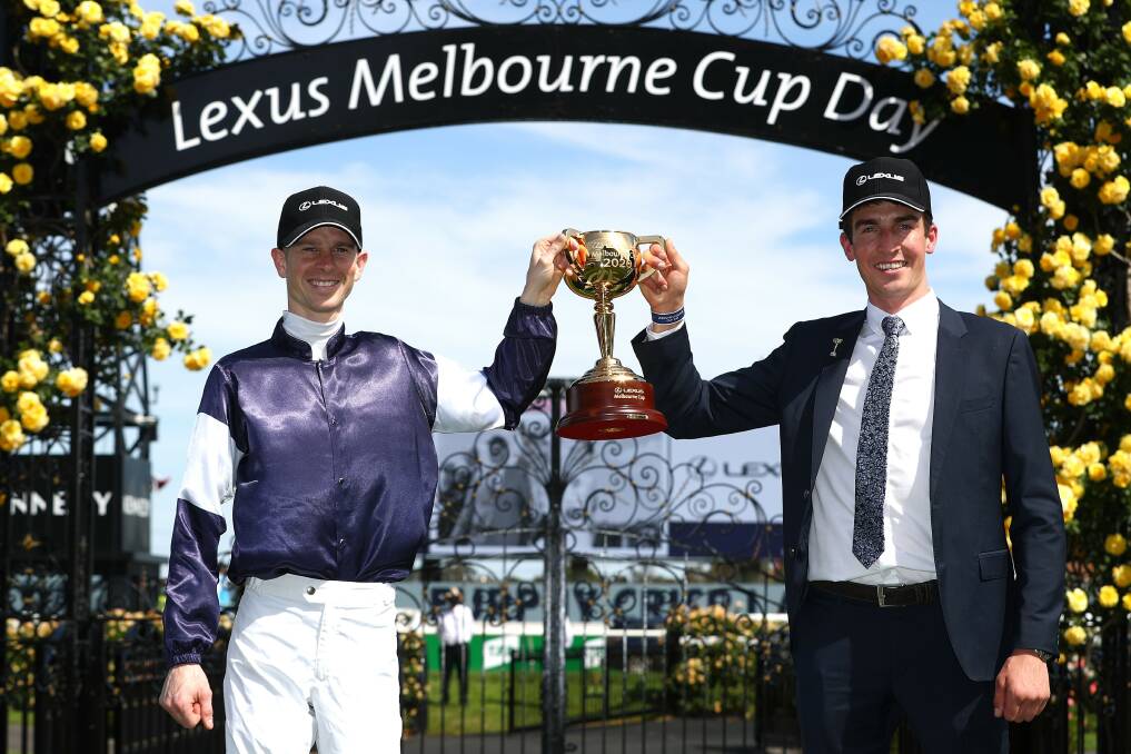 Jockey Jye McNeil and travelling foreman Mark Power pose with the 2020 Melbourne Cup after Twilight Payment's victory. Picture: Getty Images