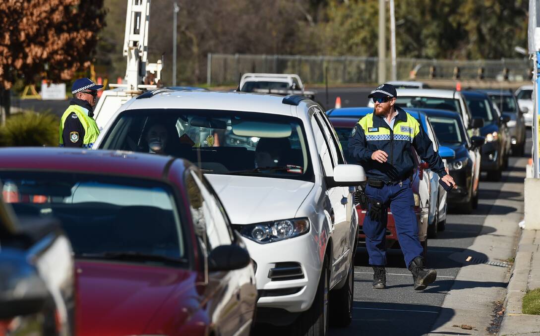 Police at a vehicle checkpoint on the NSW-Victorian border.