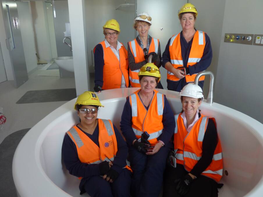 Lucy Evans, Lisa O'Donnell, Jayne Lawrence and (front) Pritty Joseph, Therese Adijans and Sally Jenkins check out a bath tub in a birthing suite in the new clinical services building under construction as part of stage one and two redevelopment of Dubbo Hospital. 					         Photo: Contributed.
