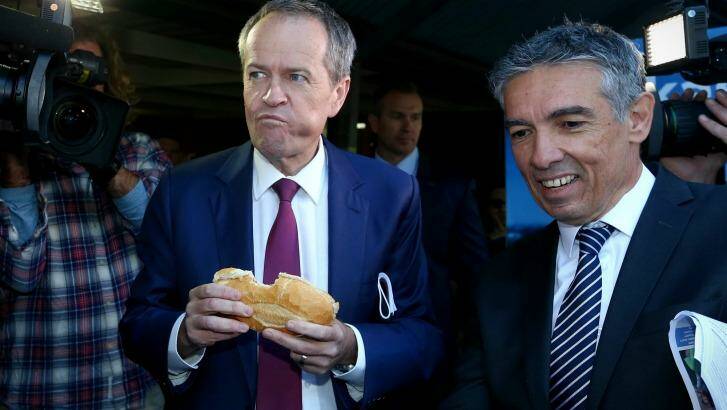 Opposition Leader Bill Shorten eats a sausage in a roll with onion and tomato sauce during the election campaign. Photo: Alex Ellinghausen