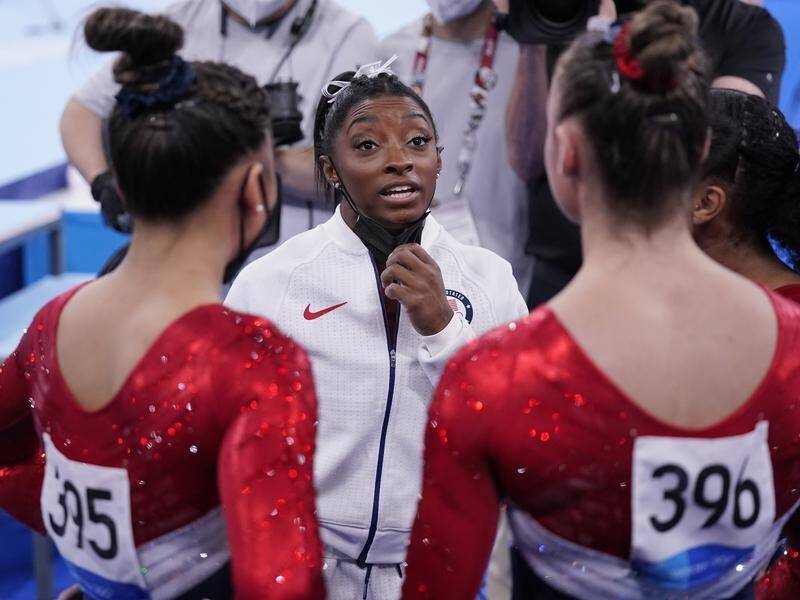 Simone Biles talks to US teammates after her withdrawal during the Olympic gymnastics team event.