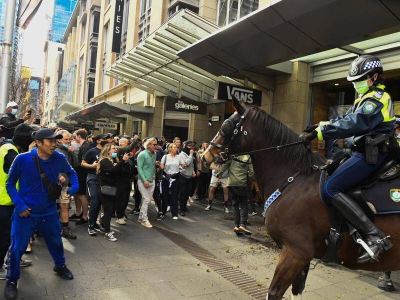 Anti-lockdown protesters face off with mounted police near Sydney Town Hall.