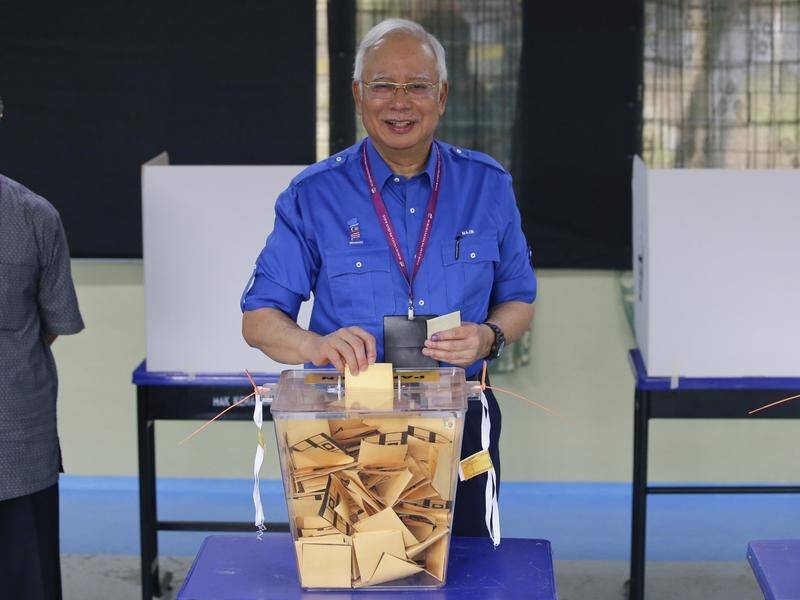 Malaysian Prime Minister Najib Razak votes in national elections in his hometown of Pekan.