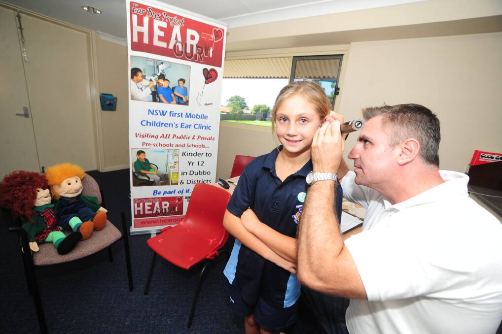 Year 3 student Shaliah Gordon at St Lawrences gets her ears tested by Gordon Rutter of Central Coast Hearing.		 
	Photo: BELINDA SOOLE
