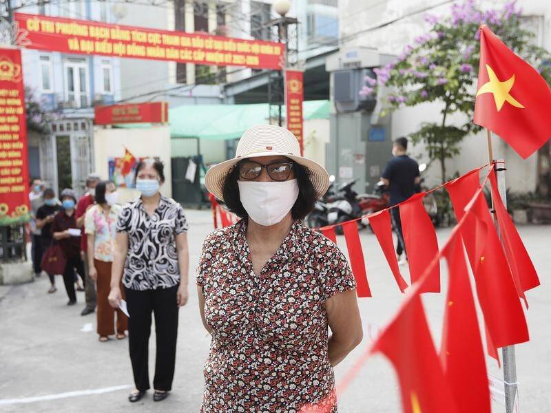 Mask-clad voters have queued to vote in VIetnam's parliamentary election.