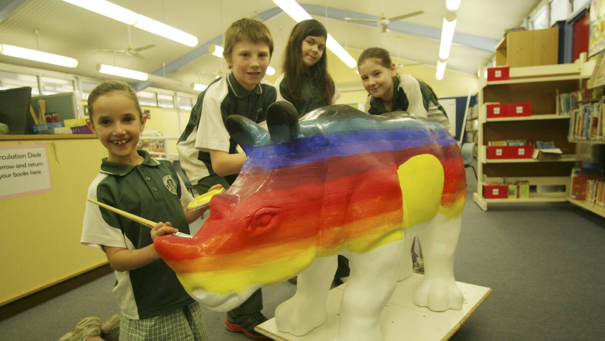 Bonnells Bay Public School. Pictured from left are students Carli Redman, Tyler Beer, Carolee Needham and Ashlee Chalmers, painting Bob the rhino calf sculpture. For story on the school's participation in the Taronga Wild! Rhinos art and conservation program. Sept 2013. Picture by David Stewart